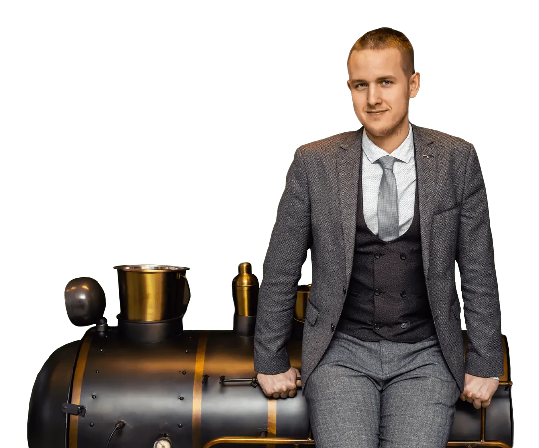 Tomáš Lukas opřený o stylový barový stolek